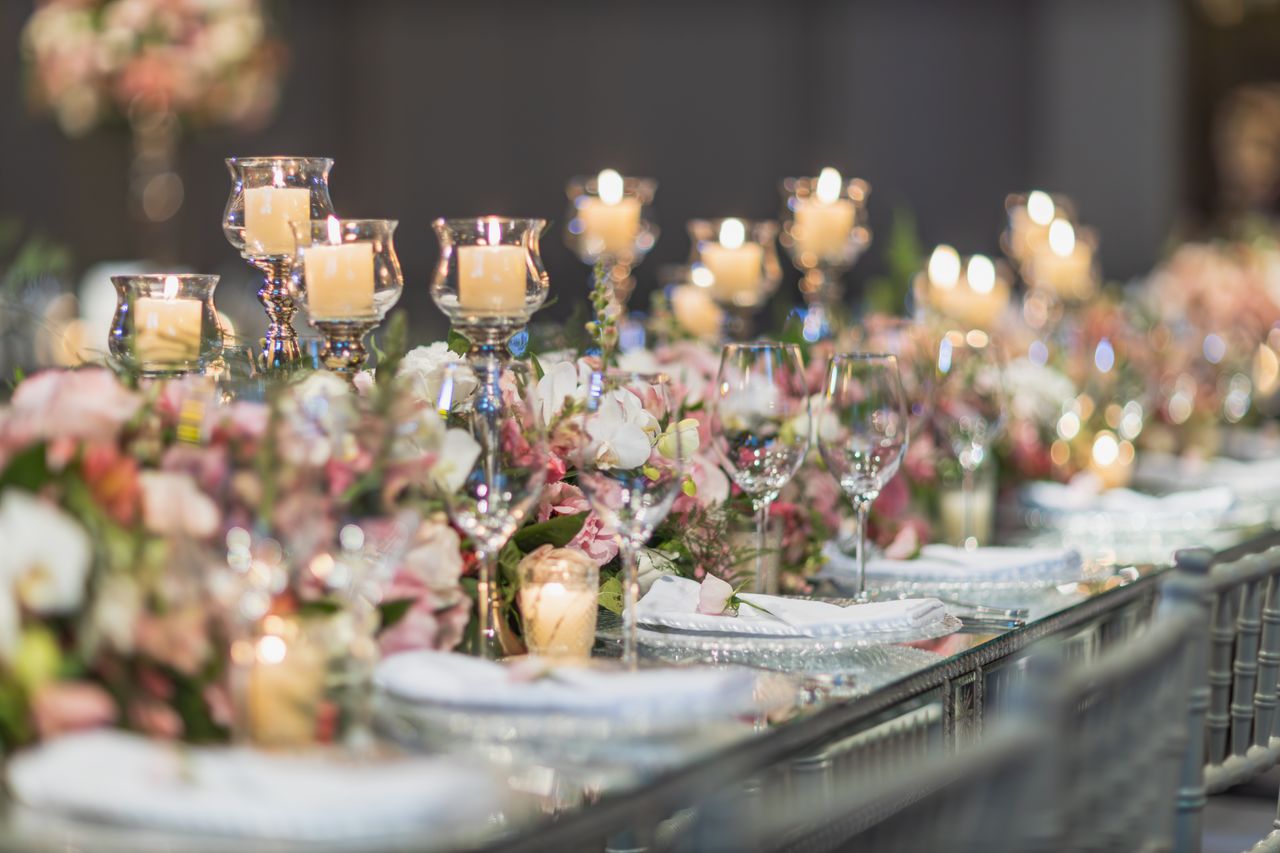 A beautifully decorated wedding table featuring candles and floral arrangements, perfect for elegant receptions.