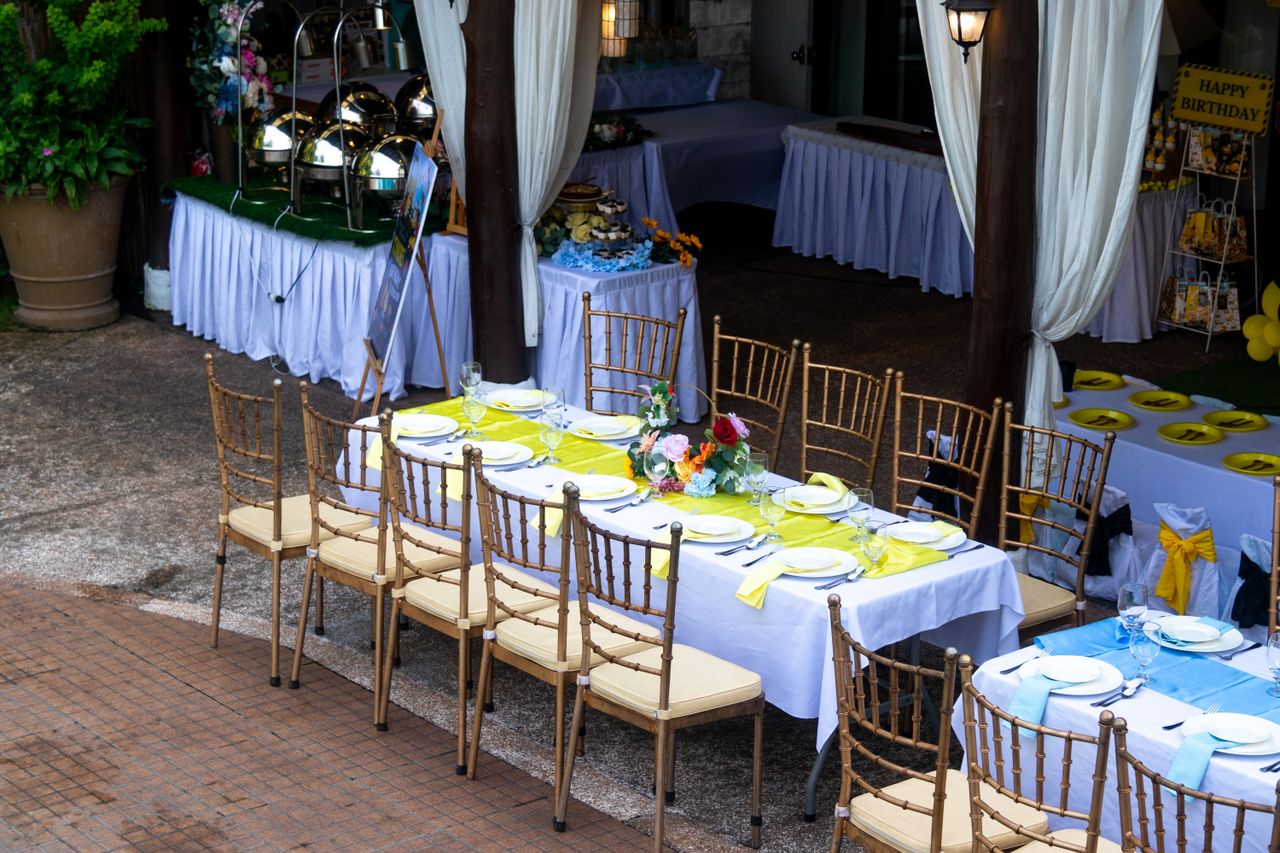 A beautifully arranged outdoor dining setting for a birthday party with vibrant decor and table arrangements.